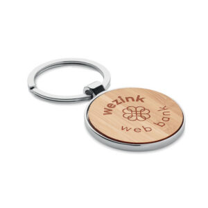 Key ring with logo BALLARAT Key ring with logo round shaped in zinc alloy and bamboo front. Bamboo is a natural product, there may be slight variations in color and size per item,                                                                                                                                                                                        which can affect the final decoration outcome. Available color: Wood Dimensions: Ø4X7,5X0,4CM Width: 0.4 cm Height: 7.5 cm Diameter: 4 cm Volume: 0.088 cdm3 Gross Weight: 0.032 kg Net Weight: 0.027 kg Depending on the surface we can use embroidery, engraving, 360° imprint or screen print.